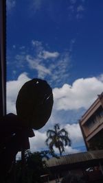 Low angle view of person holding umbrella against sky