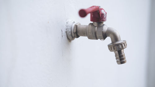 Close-up of faucet against wall