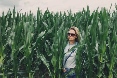 Young woman wearing sunglasses standing on field