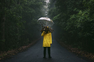 Leaves falling on man holding umbrella