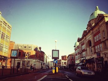 View of city street against blue sky