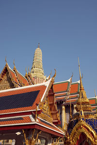 Low angle view of temple against building against clear sky