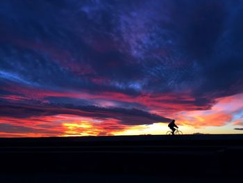 Silhouette man against orange sky during sunset