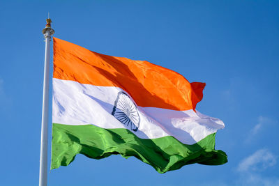 Low angle view of flag against blue sky