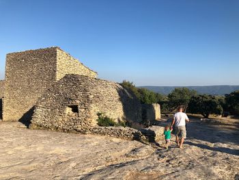 Rear view of father with baby walking at historic place