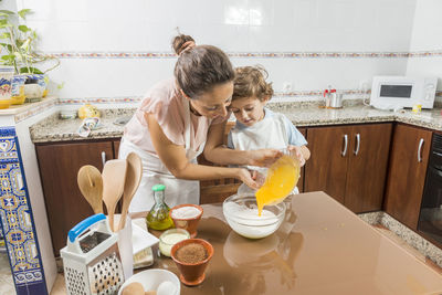 Woman and son cooking on table