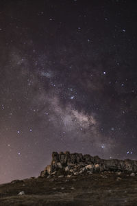 Scenic view of rock formation against sky at night