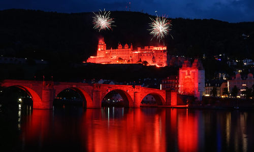 View of illuminated bridge over river at night