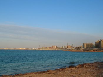 Scenic view of sea and buildings against sky