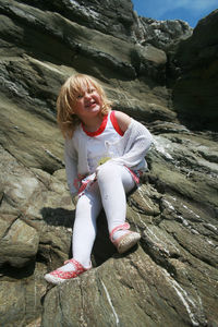 Portrait of woman sitting on rock