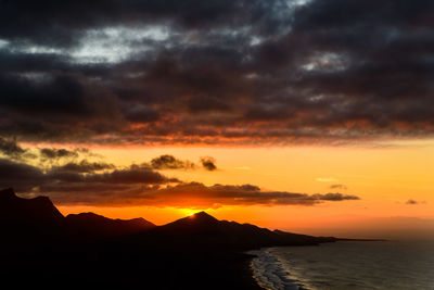 Sunset at playa de cofete and the jandia hills.