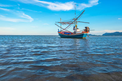 Fishing boat in sea against sky