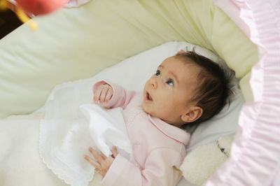 Cute baby girl lying in crib