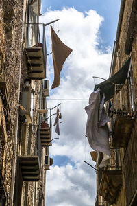 Low angle view of laundry hanging on building balconies
