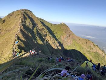 People on mountain road against sky