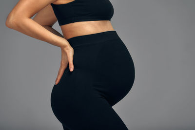 Midsection of woman standing against white background