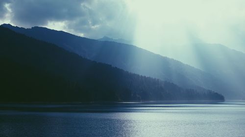 Scenic view of lake and mountains against sky