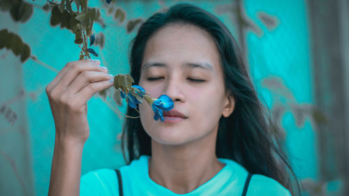 Close-up of woman smelling flower