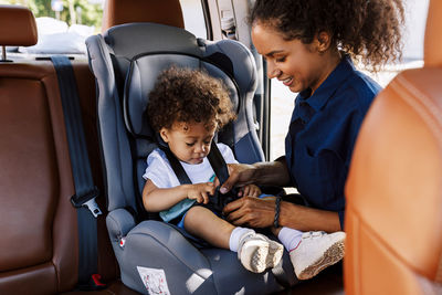 Woman with toddler son sitting on seat in car