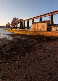 Low angle view of bridge over river against clear sky