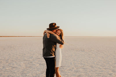 Rear view of woman standing at beach