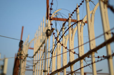 Low angle view of barbed wire against clear sky