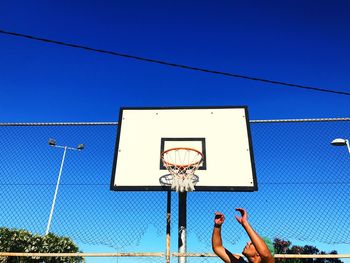 Low angle view of basketball hoop against blue sky