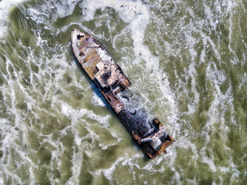 Aerial view of abandoned ship in sea against sky