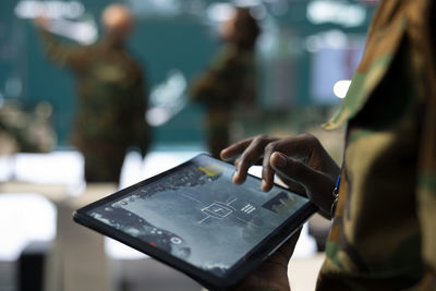 Midsection of woman using digital tablet