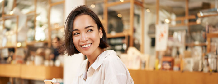 Portrait of young woman standing in store