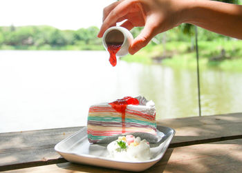 Person holding ice cream cone on table