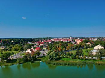 Scenic view of lake by buildings against blue sky