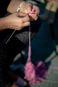 Cropped hand of woman knitting at home