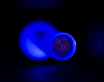 Close-up of illuminated light bulb against black background