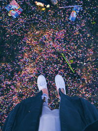 Low section of woman standing on confetti covered in back yard