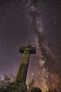 Low angle view of cross against sky at night