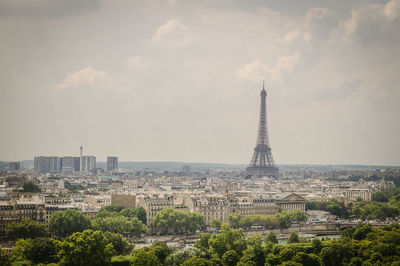 Aerial view of cityscape against cloudy sky during sunny day