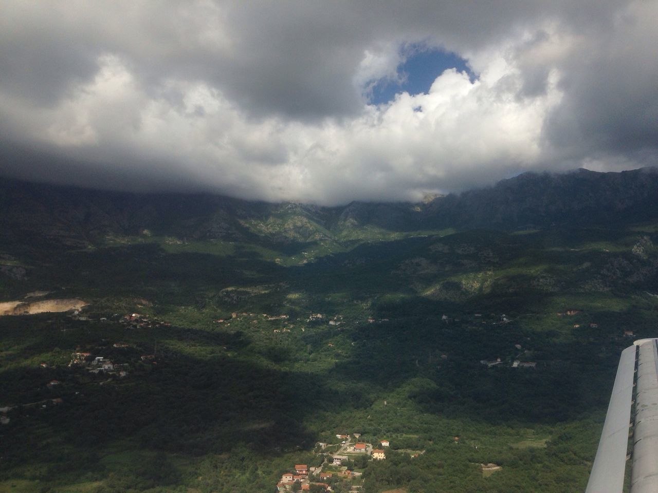 sky, mountain, cloud - sky, landscape, scenics, tranquil scene, cloudy, tranquility, beauty in nature, nature, mountain range, high angle view, green color, cloud, tree, idyllic, hill, non-urban scene, built structure, weather