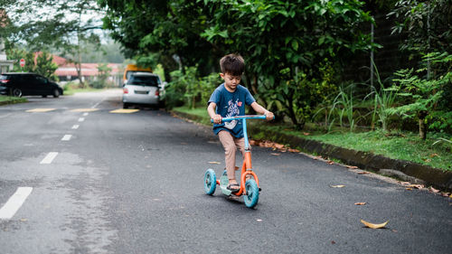 Full length of boy riding motorcycle on road