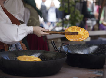 Woman frying torto de maíz, corn bread is a typical food in asturias