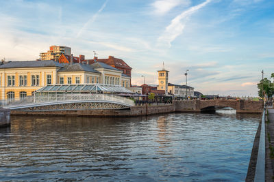 Bridge over river in city against sky