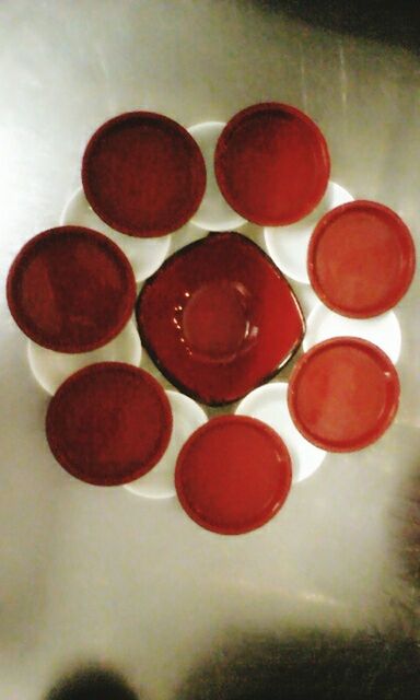 indoors, red, still life, table, close-up, high angle view, no people, variation, in a row, large group of objects, arrangement, directly above, flooring, wall - building feature, food and drink, wood - material, floor, circle, selective focus, group of objects