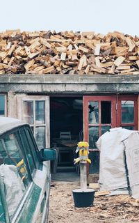 Stack of logs against building