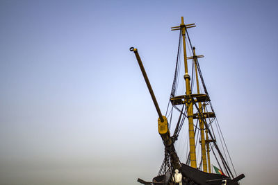 Low angle view of cranes against clear sky