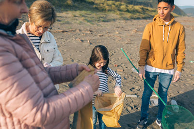 Family collecting garbage at beach