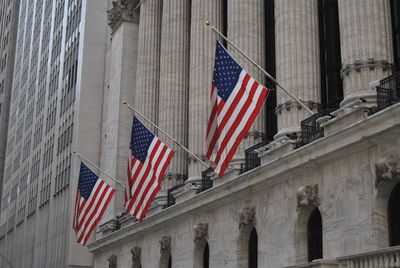 Low angle view of flag against building in city