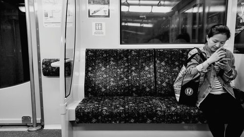 Close-up of young woman sitting on bench