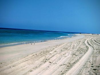 Scenic view of beach against clear blue sky