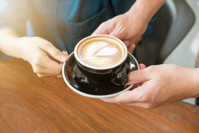 Midsection of man holding coffee cup