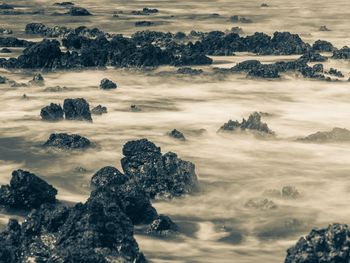 Scenic view of rocks on shore against sky